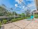 Lounge chair on the screened patio with brick pavers and lush landscaping at 4372 Water Oak Way, Palm Harbor, FL 34685