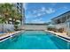 Enjoy a community pool with a lounging area under a clear blue sky in a vibrant neighborhood at 4400 37Th S St # 4, St Petersburg, FL 33711