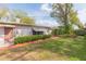 Lovely backyard with manicured lawn, mature trees, partial shade, brick pathway, and traditional exterior at 4517 S Renellie Dr, Tampa, FL 33611