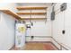 Unfinished basement featuring a water heater, electrical box, and wooden shelves at 4517 S Renellie Dr, Tampa, FL 33611