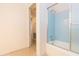 This bathroom features blue tiled walls, a bathtub, and a glass shower door at 4517 S Renellie Dr, Tampa, FL 33611