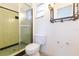 Bathroom showcasing a shower with green tile, a toilet, and an ornate decorative mirror at 4517 S Renellie Dr, Tampa, FL 33611