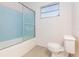 The bathroom has blue wall tiles, a white shower tub, and a matching white toilet at 4517 S Renellie Dr, Tampa, FL 33611