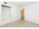 Cozy bedroom featuring neutral walls and tiled floor, with closet and hallway access at 4517 S Renellie Dr, Tampa, FL 33611