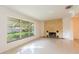 Living room with a brick fireplace, terrazzo floors, and large windows providing ample light at 4517 S Renellie Dr, Tampa, FL 33611