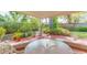 Covered patio with a table, various potted plants, brick flooring, and a view of the backyard at 4517 S Renellie Dr, Tampa, FL 33611