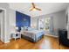 Stylish bedroom features hardwood floors, a ceiling fan, a bold blue accent wall, and lots of natural light at 511 27Th N Ave, St Petersburg, FL 33704
