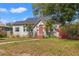 Charming bungalow-style home featuring a red front door, lush landscaping, and a curved walkway at 511 27Th N Ave, St Petersburg, FL 33704