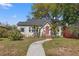 Charming bungalow-style home featuring a red front door, lush landscaping, and a curved walkway at 511 27Th N Ave, St Petersburg, FL 33704