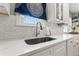 Close-up of a kitchen sink with white countertops, subway tile backsplash, and modern faucet with filtered water tap at 511 27Th N Ave, St Petersburg, FL 33704