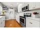 Cozy kitchen with stainless steel appliances, white cabinets, stylish decor, and hardwood flooring at 511 27Th N Ave, St Petersburg, FL 33704