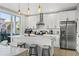 Modern kitchen featuring white cabinetry, stainless steel appliances, a stylish range hood, and an island with seating at 5402 31St S Ave, Gulfport, FL 33707