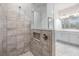 Bathroom with tiled shower, glass door, double vanity, and white cabinets at 5614 Silver Sun Dr, Apollo Beach, FL 33572