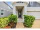 Inviting home entrance adorned with verdant shrubbery and leading to a sleek, glass-paneled front door at 5614 Silver Sun Dr, Apollo Beach, FL 33572