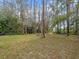 Expansive backyard with mature trees, offering a peaceful setting with the lake visible in the background at 6302 Fitzgerald Rd, Odessa, FL 33556