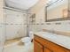 Bathroom features tile floors, shower, toilet, wooden vanity, granite countertop and a large mirror at 6302 Fitzgerald Rd, Odessa, FL 33556