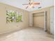 Bright bedroom features tile flooring and a closet, and a view of the greenery outside at 6302 Fitzgerald Rd, Odessa, FL 33556