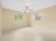This bedroom features tile floors, ceiling fan, and natural light from the two windows at 6302 Fitzgerald Rd, Odessa, FL 33556