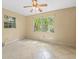 Bright bedroom features tile flooring and a view of the lush greenery outside at 6302 Fitzgerald Rd, Odessa, FL 33556