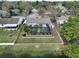 Aerial view of a private backyard featuring a screened-in pool, wood fence, and surrounding greenery at 641 Bay Lake Trl, Oldsmar, FL 34677