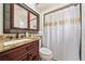 Elegant bathroom featuring granite countertops, a decorative mirror, and a shower with a gold-accented shower curtain at 641 Bay Lake Trl, Oldsmar, FL 34677