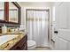 Elegant bathroom featuring granite countertops, a decorative mirror, and a shower with a gold-accented shower curtain at 641 Bay Lake Trl, Oldsmar, FL 34677