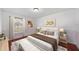 Staged bedroom with hardwood floors, neutral walls, window, bed, bedside tables, and artwork at 641 Bay Lake Trl, Oldsmar, FL 34677