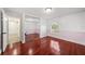 Empty bedroom with hardwood floors, neutral walls, a mirrored closet, and a window for natural light at 641 Bay Lake Trl, Oldsmar, FL 34677
