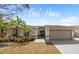 Charming single-story home featuring a manicured lawn, tropical landscaping, and a two-car garage at 641 Bay Lake Trl, Oldsmar, FL 34677