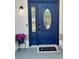 Close-up of a stylish blue front door with decorative glass and a welcoming 'home' doormat at 641 Bay Lake Trl, Oldsmar, FL 34677