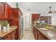Kitchen with cherry cabinets, granite counters, stainless appliances and sink, and a serving counter at 641 Bay Lake Trl, Oldsmar, FL 34677