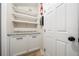 Laundry room with a gray granite countertop, white cabinets and shelving for storage at 641 Bay Lake Trl, Oldsmar, FL 34677