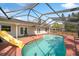 Backyard screened pool with a slide, ladder, and a patio with a relaxing rocking chair at 641 Bay Lake Trl, Oldsmar, FL 34677