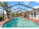 Sparkling pool in a screened enclosure, palm trees, a slide, and comfortable patio seating at 641 Bay Lake Trl, Oldsmar, FL 34677