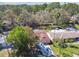 An aerial view of the home showcasing the landscaping, driveway with parked RV, and the surrounding wooded neighborhood at 7131 Wedgewood Dr, New Port Richey, FL 34652