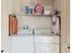 Convenient laundry room with white washer, dryer, and storage shelf at 7222 Sharpsburg Blvd, New Port Richey, FL 34653