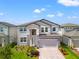 Charming two-story home boasting a stone facade, light blue shutters, and a well-maintained front yard at 7276 Notched Pine Bnd, Wesley Chapel, FL 33545