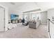 Spacious living room featuring plush carpeting, tray ceiling, and a well-lit workspace at 7276 Notched Pine Bnd, Wesley Chapel, FL 33545