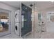 Well-lit renovated bathroom, with glass enclosed shower, laundry units, and tile flooring at 7998 Causeway N Blvd, St Petersburg, FL 33707