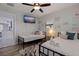 Bright bedroom with twin beds, ceiling fan, mounted TV, and beach-themed decor at 7998 Causeway N Blvd, St Petersburg, FL 33707