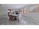 Bright dining room with modern table, chairs, fireplace, and large window with shutter shades at 7998 Causeway N Blvd, St Petersburg, FL 33707