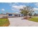 Attractive single-story home featuring manicured landscaping, a long driveway, and awnings at 7998 Causeway N Blvd, St Petersburg, FL 33707