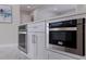 Close-up of kitchen island featuring stainless steel oven and microwave with white cabinetry at 7998 Causeway N Blvd, St Petersburg, FL 33707