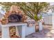 Outdoor kitchen complete with brick pizza oven, stainless steel grill, and a granite countertop at 7998 Causeway N Blvd, St Petersburg, FL 33707