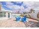 Inviting pool area with blue Adirondack chairs, stylish pavers, and a well-maintained privacy fence at 7998 Causeway N Blvd, St Petersburg, FL 33707