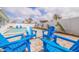 Relaxing poolside area with blue Adirondack chairs offering a perfect spot to unwind at 7998 Causeway N Blvd, St Petersburg, FL 33707