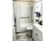 Well-lit bathroom featuring a shower-tub combo, safety bar, wood-look floors, and a vanity at 8080 112Th St # 206, Seminole, FL 33772