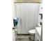 Bright bathroom with white fixtures, gray wood-look floor and matching shower curtain at 8080 112Th St # 206, Seminole, FL 33772