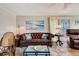 Comfortable living room featuring a leather sofa, beach-themed decor, and wood-look flooring at 845 Jolanda Cir, Venice, FL 34285