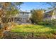 Backyard view of the home with a small wooden deck and lush lawn at 864 15Th Ne Ave, St Petersburg, FL 33704